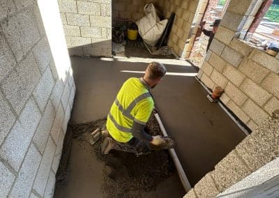 Floor screed contractor working at a new building at Braybrooke, Northamptonshire