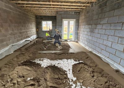 Workers installing floor screed