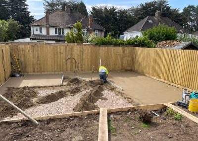 Contractor using a straight edge to accurately apply floor screed material and create a perfectly level floor surface for a patio area