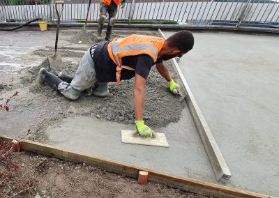 Floor screeding contractor using a trowel to accurately smooth floor screed material and create a perfectly level floor surface