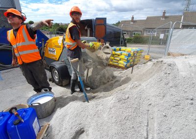 Contractors loading floor screed material into a screed pump