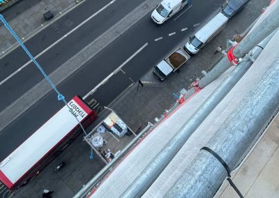 View down onto a busy London street, showing floor screed materials at ground level and hoist