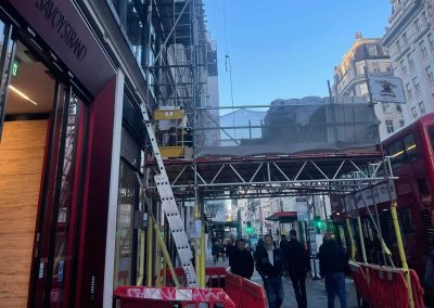 Busy London street with scaffold and floor screed materials, allowing free access at ground level
