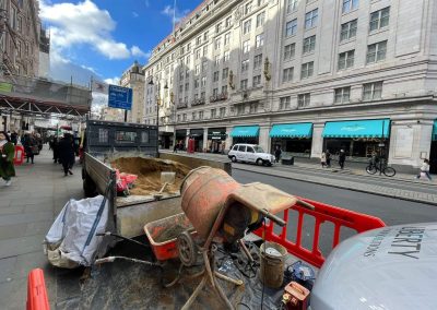 Busy London street with floor screed materials, Liberty builders truck and cement mixer