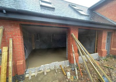 Newly installed floor screed surface in an open fronted double garage