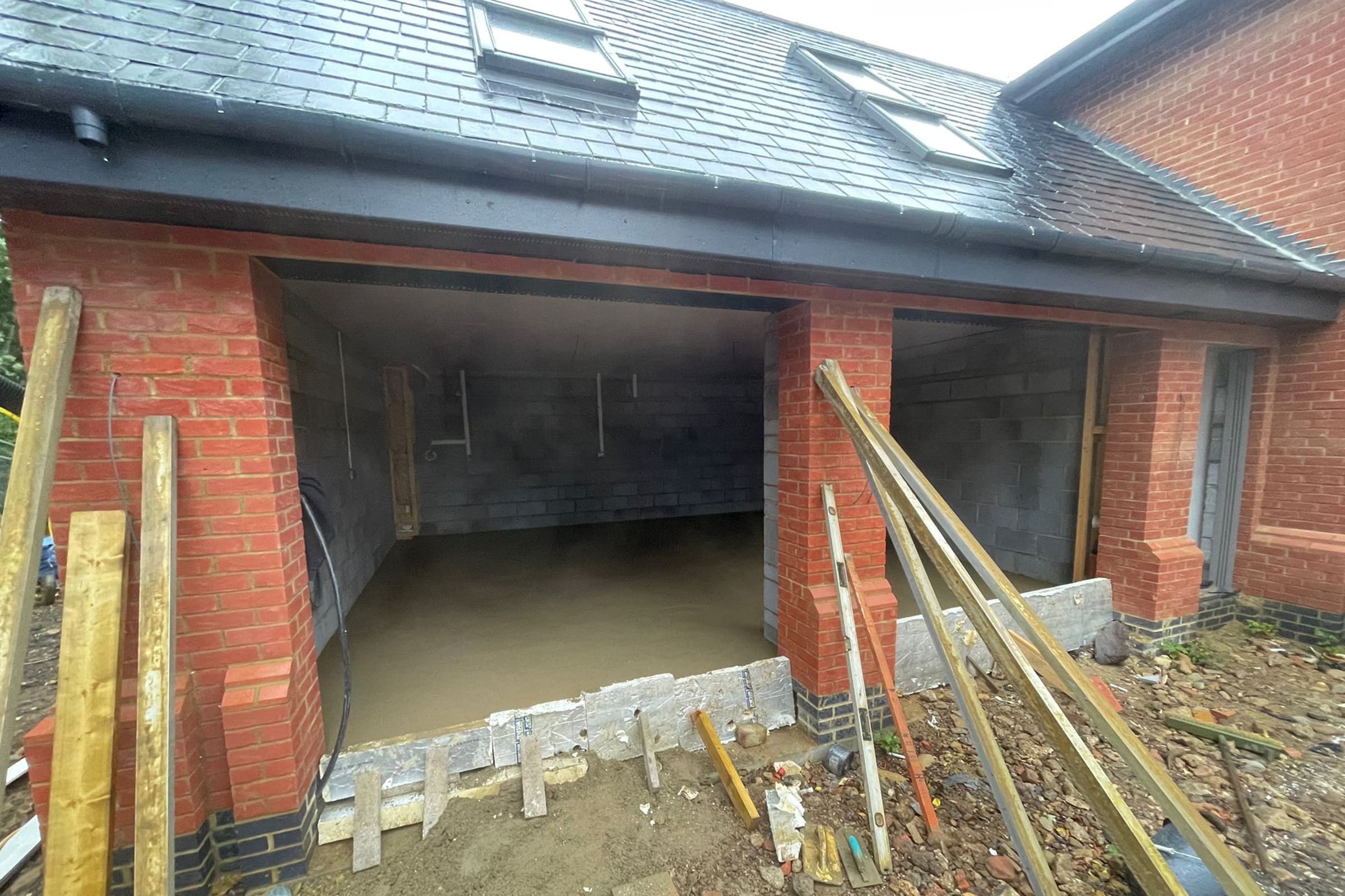 Newly installed floor screed surface in an open fronted double garage