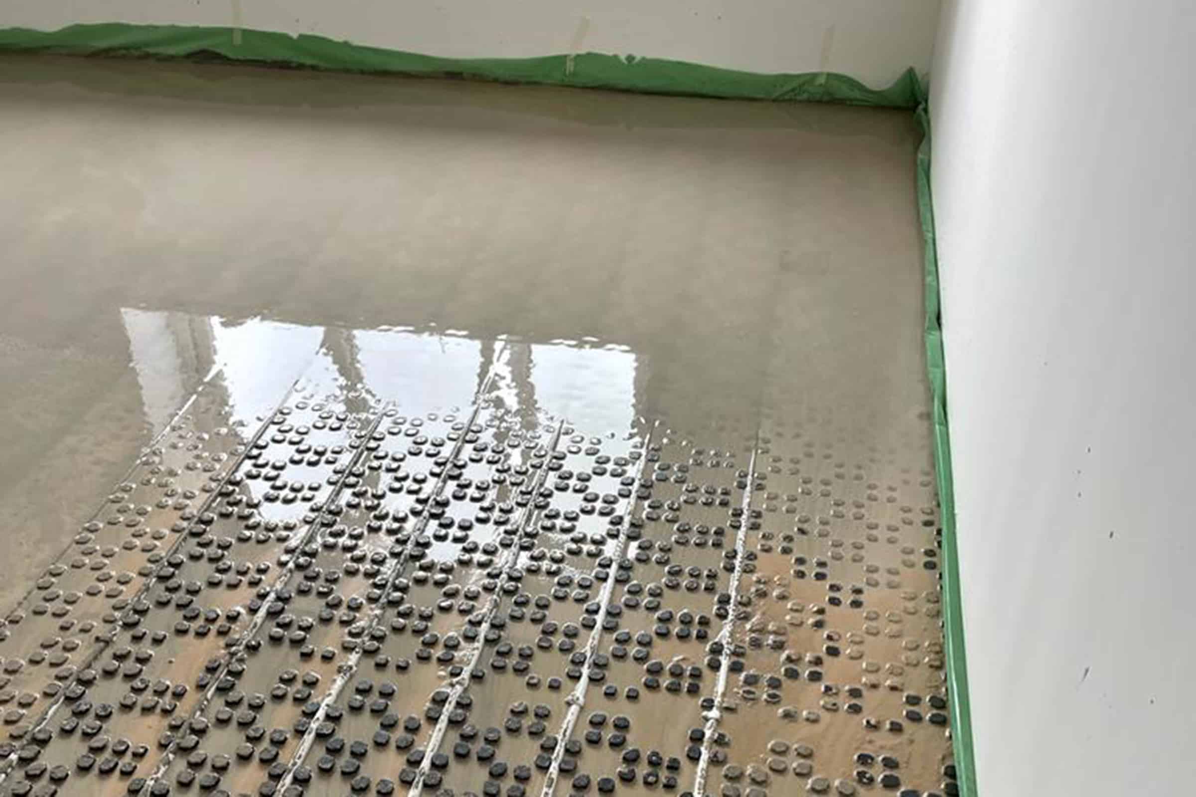 Partially covered underfloor heating pipes