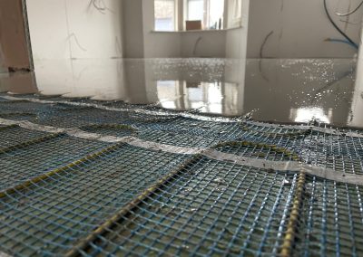 Underfloor heating pipes in situ at a new build property partially covered by self levelling screed
