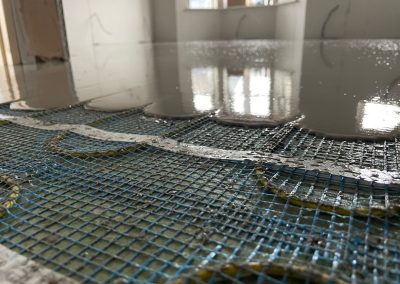 Underfloor heating pipes in situ at a new build property partially covered by self levelling screed
