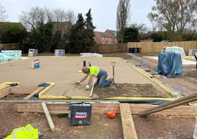 Man working on a floor screed project at a new build building site plot