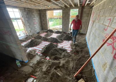 Contractor with partially installed floor screed surface at a newly build property