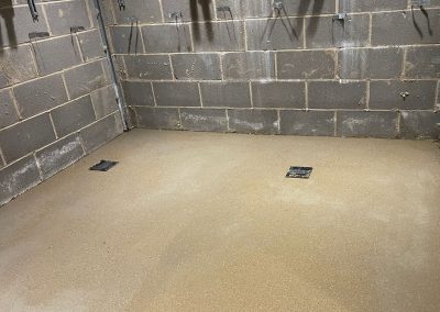 Newly installed floor screed surface in a shower cubicle at Wembley Stadium