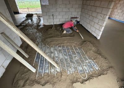 Worker installing underfloor heating screed
