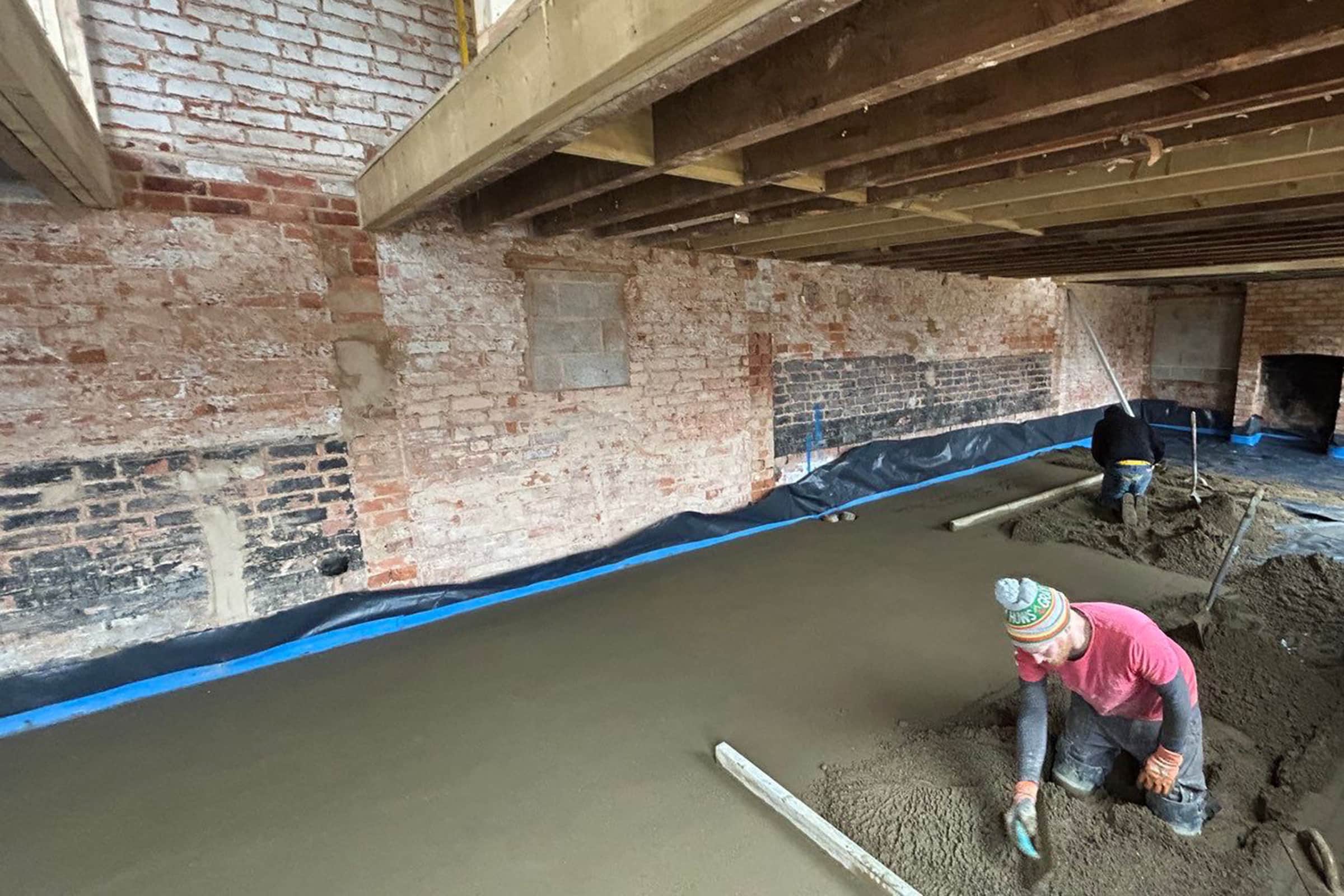 Workers installing floor screed